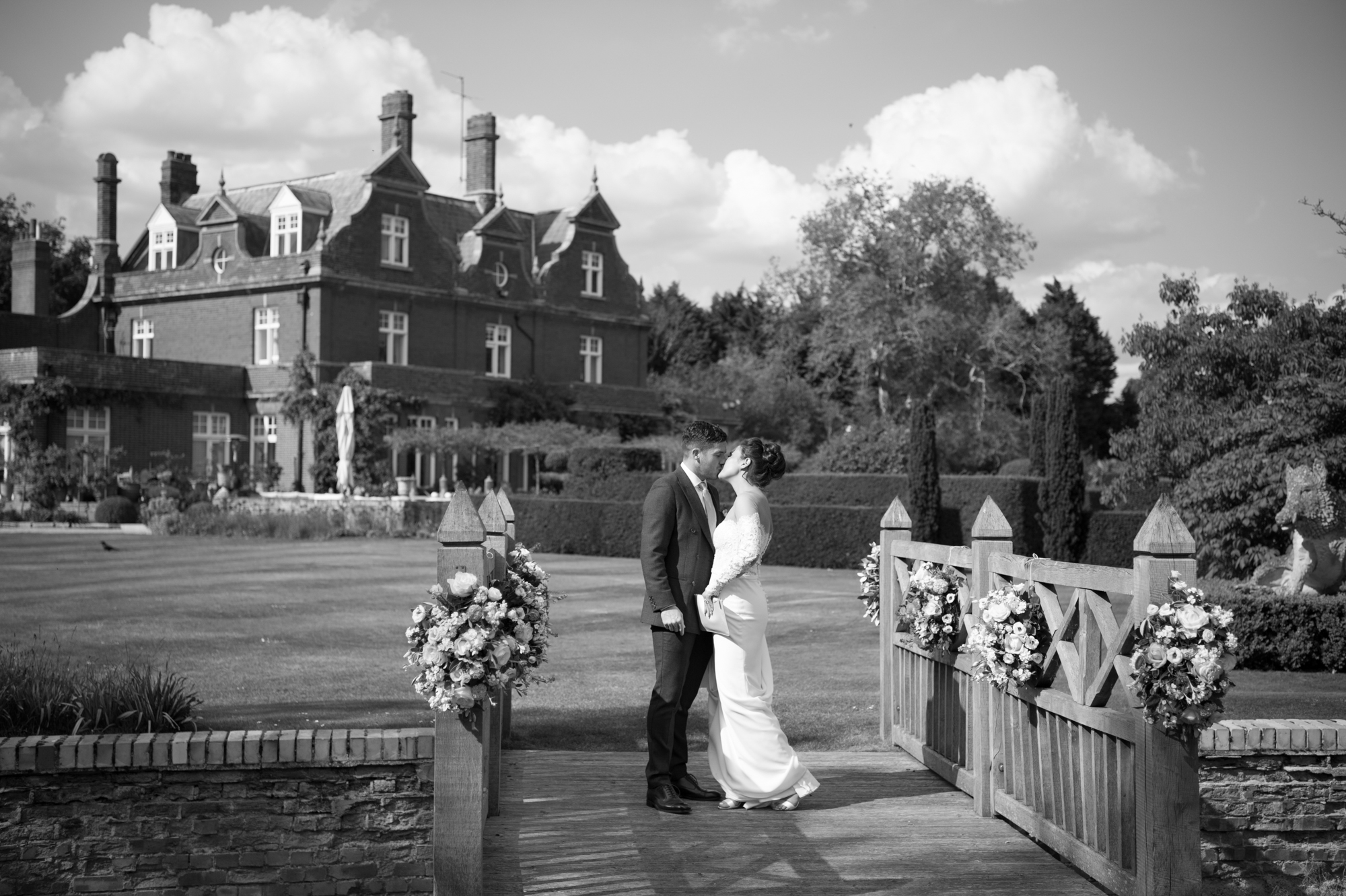 Black and white kissing shot of bride and groom at Chippenham park wedding venue
